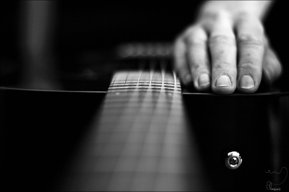Gitarre , Sillleben. Hand auf schwarzer Gitarre,
Schwarzweißfotografie